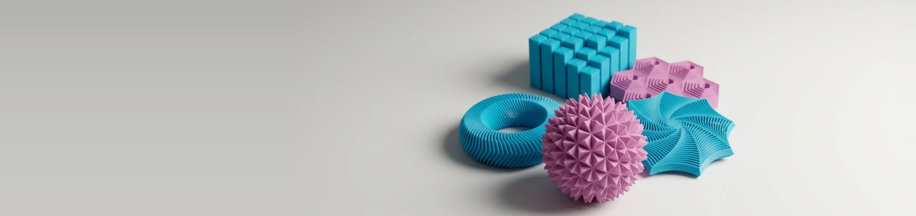 Fem 3D-printede fidgets i turkis og pink: pigbold, fidgetring, bikube-plade, stjerne og slim-klodser