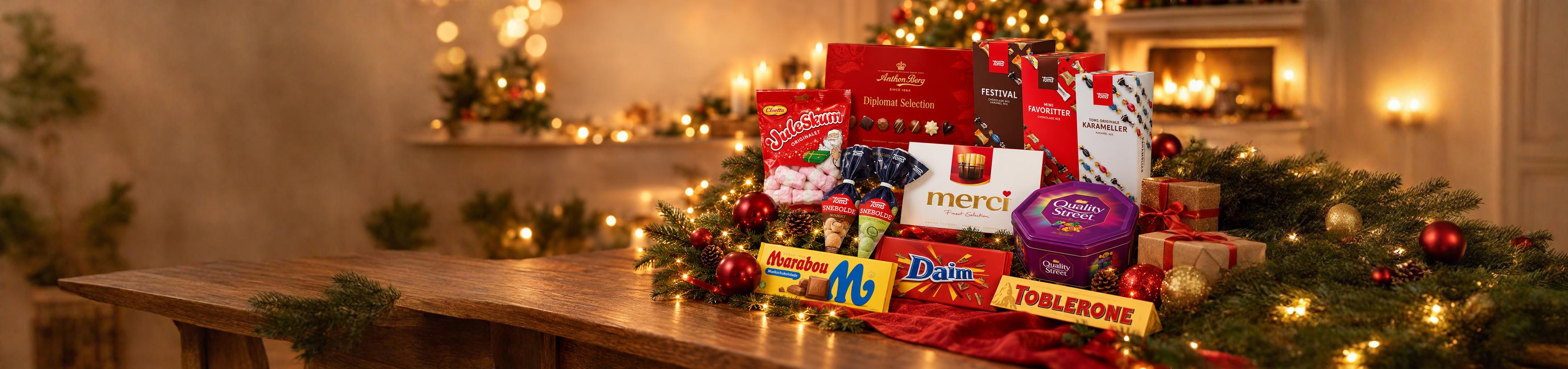Juleslik og chokolade på et julepyntet bord: Juleskum, Snebolde, Merci, Quality Street, Toms, Anthon Berg, Marabou, Daim og Toblerone